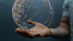 Eine Hand hält einen virtuellen Globus, der aus verschiedenen Punkten besteht, die miteinander vernetzt sind.