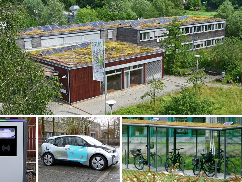 NUA-Gebäude mit Holzfassade, Photovoltaikanlage und Dachbegrünung, E-Dienstfahrzeug des LANUV, Fahrradstation des LANUV und Ladesäule